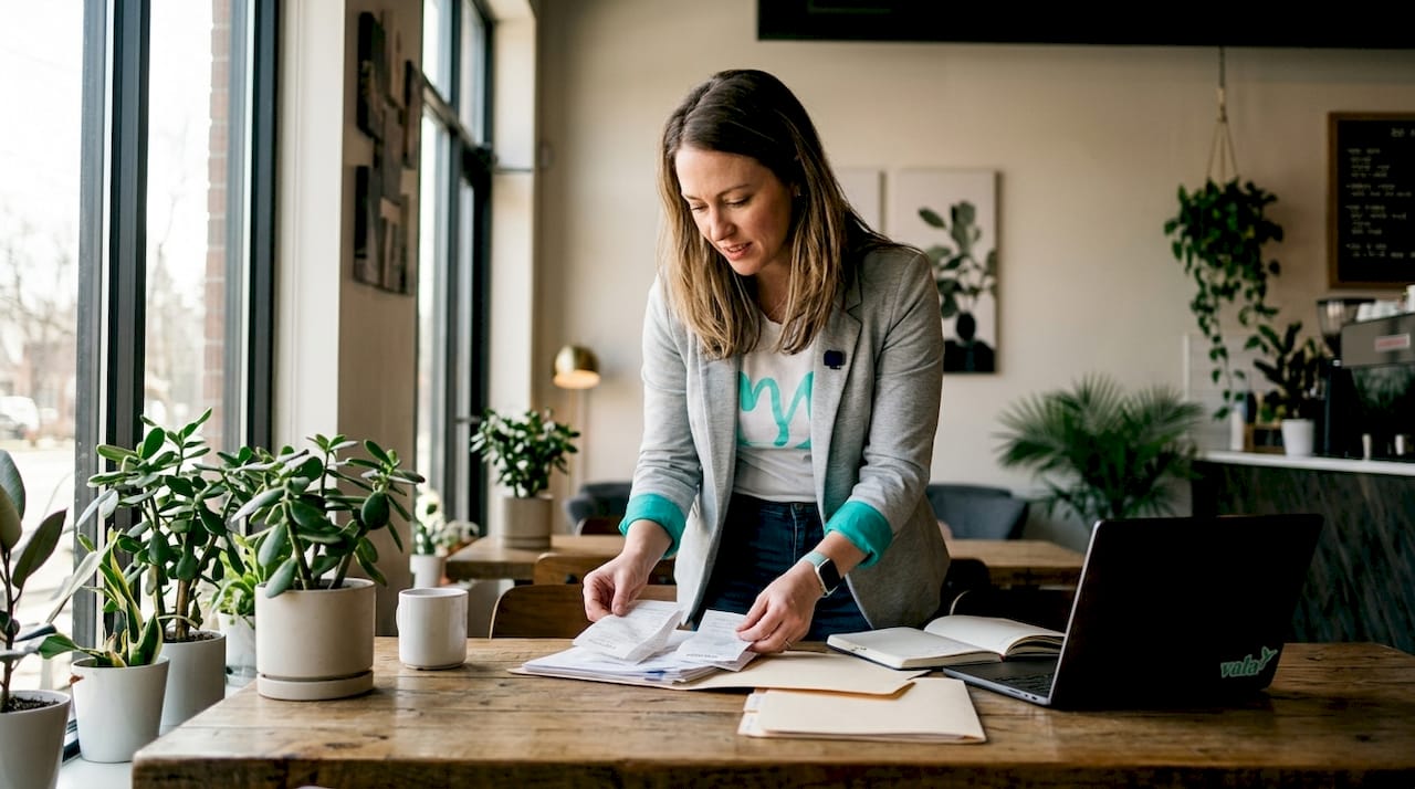 Small business owner categorizing expenses at desk
