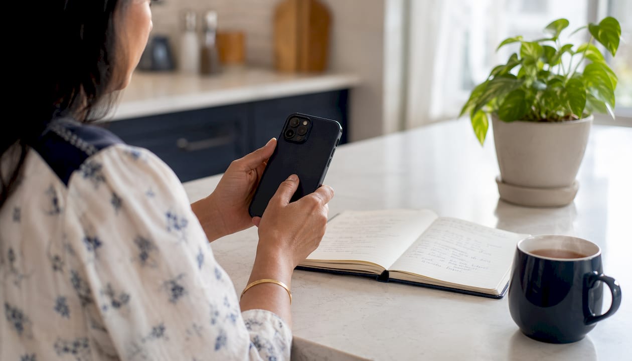 Woman managing subscriptions on smartphone overhead view