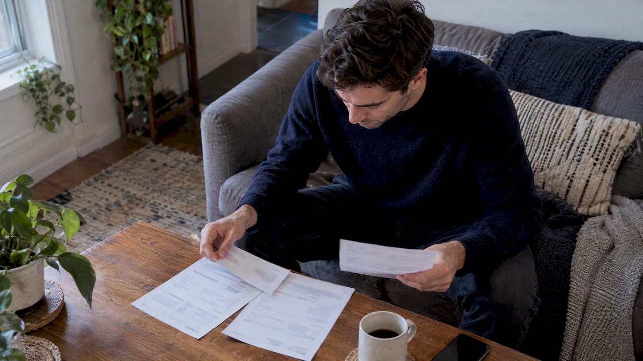 Person comparing three subscription billing statements